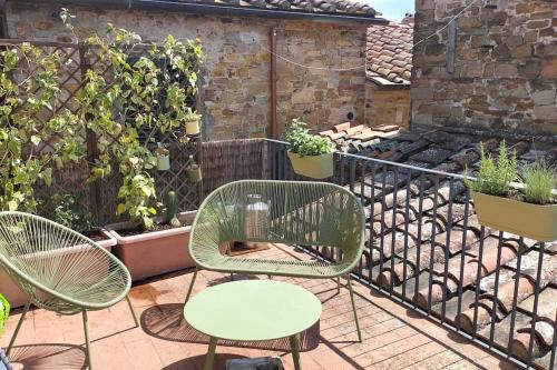 波吉奥的圣多纳托La tua casa nel Chianti的种植了植物的阳台,配有三把椅子和一张桌子