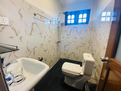 努沃勒埃利耶旅巢宾馆的浴室配有白色卫生间和盥洗盆。