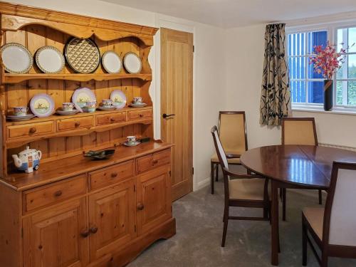 Little EatonWindmill Cottage的一间用餐室,配有木柜和盘子