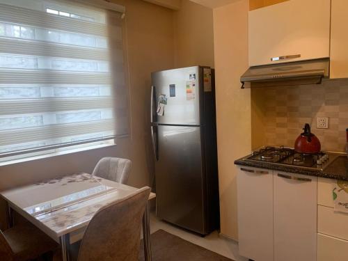 巴库Dream Home的厨房配有不锈钢冰箱和桌子
