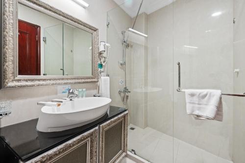 多哈主席酒店的白色的浴室设有水槽和镜子