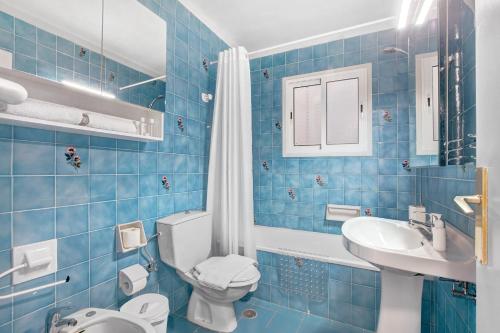 塔科龙特Apartamentos Tamara的蓝色瓷砖浴室设有卫生间和水槽