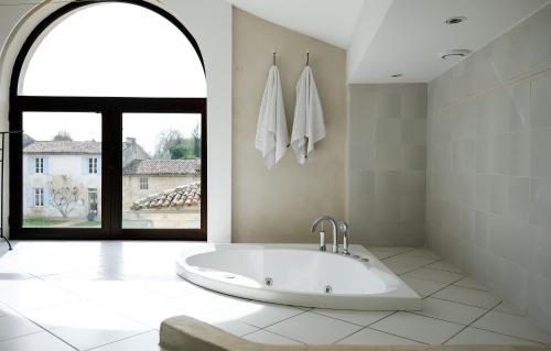 Saint-PorchaireChâteau de La Vallade的一间带大浴缸及窗户的浴室