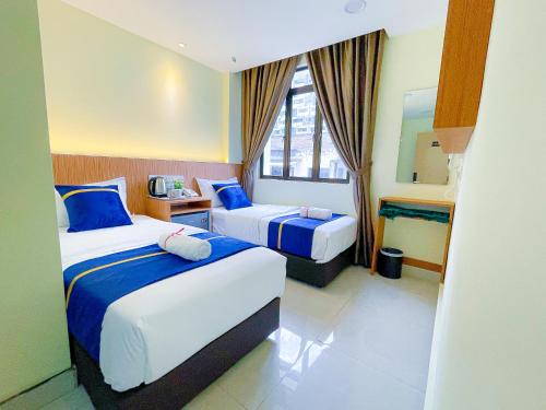 吉隆坡Astar Hotel Bukit Bintang的酒店客房,设有两张床和镜子