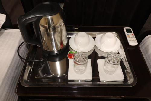 布哈拉Al Bukhari Boutique Hotel的一个带咖啡壶和茶几上的杯子的托盘