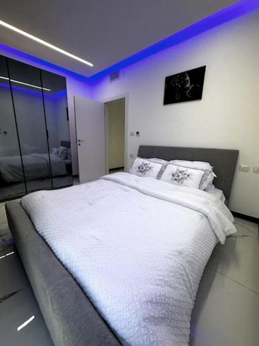 耶路撒冷Stylish and spacious 3BR apartment in the heart of Jerusalem! اهلا وسهلا的一间卧室配有一张白色大床和紫色灯