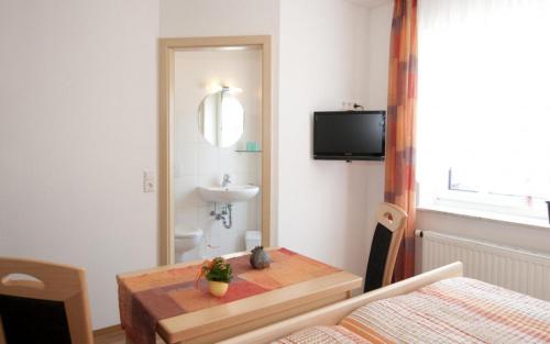 UnlingenLandgasthof Sonne的小房间设有桌子、水槽和镜子