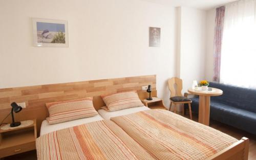 UnlingenLandgasthof Sonne的一间卧室配有两张床和蓝色的沙发