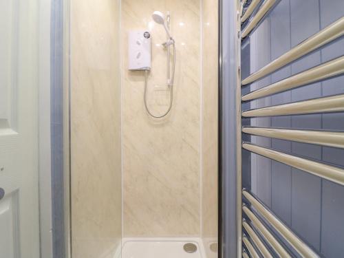 TuxfordCheriton的浴室铺有蓝色瓷砖,设有淋浴。