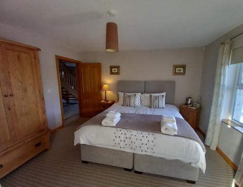 InishmoreInishmore Island B&B的一间卧室配有一张大床和毛巾