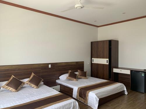 谅山Khách sạn Ánh Trăng的酒店客房设有两张床和电视。