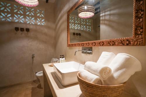 马特姆维Villa Tulia的浴室配有盥洗盆、镜子和毛巾