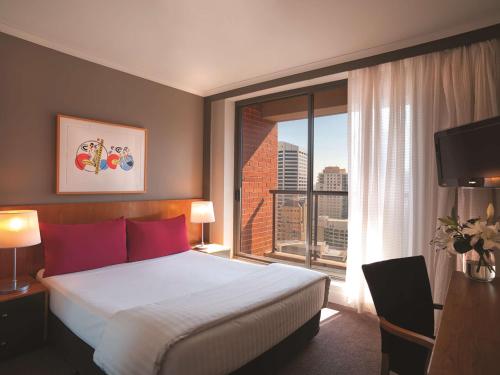 悉尼悉尼市政厅阿迪娜公寓式酒店的酒店客房设有一张床和一个大窗户