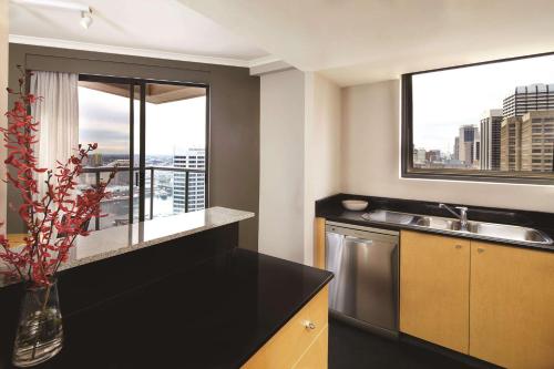 悉尼悉尼市政厅阿迪娜公寓式酒店的厨房设有水槽和窗户。