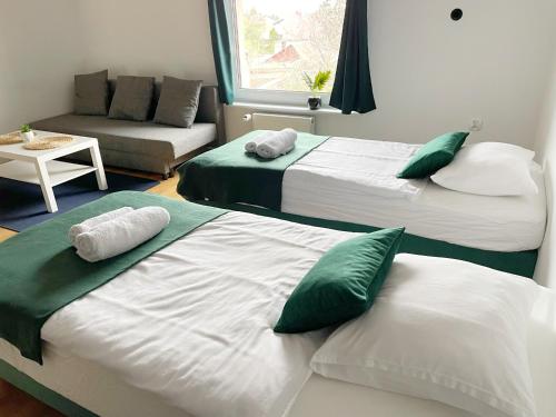 马尔堡Główna Apartamenty Nad Nogatem的两张带绿色和白色枕头的床