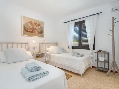 卡拉菲格拉Casa Lloc Tranquil的白色的客房设有两张床和窗户。