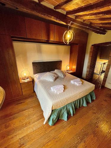 科尔托纳Pergaccio Deluxe House的一间卧室配有一张大床和两条毛巾