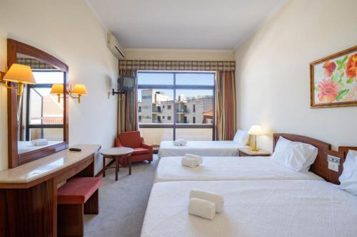 法蒂玛Villa Fatima Hotel by Umbral的酒店客房设有两张床和窗户。