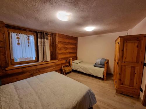 雷梅斯-诺特雷-达梅Appartamenti Lucianaz的一间卧室设有两张床和窗户。