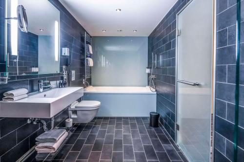 哥本哈根斯堪迪克皇宫酒店的浴室配有盥洗盆、卫生间和浴缸。