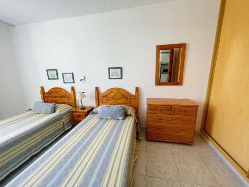 美洲海滩Torres del Sol的一间卧室配有两张床、一个梳妆台和镜子