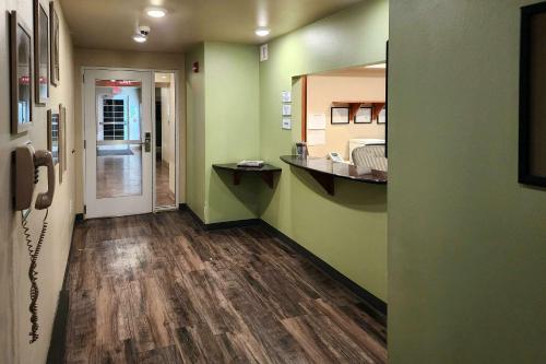 迪金森Suburban Studios的走廊上设有绿色墙壁和木地板的房间