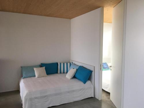 滨湖新锡德尔Ferienhaus am See Neusiedl的一间卧室配有一张带蓝色和白色枕头的床