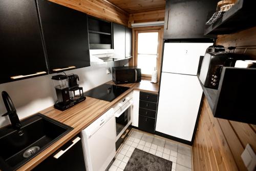 科林基拉Kolin Vernetti 1的一间小厨房,配有黑色橱柜和白色家电