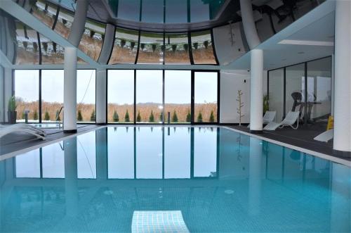 科沃布热格Westin House Resort Kołobrzeg Apartament DELUX的一座带大窗户的建筑内的游泳池