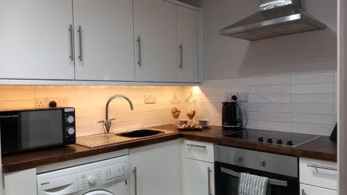 BroomfieldSoulFul Stays Chelmsford的厨房配有白色橱柜、水槽和微波炉