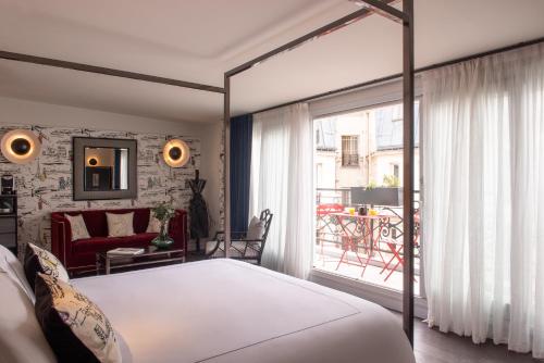 巴黎Mom'Art Hotel的一间带大床的卧室和一个阳台