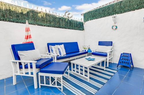 阿罗纳2 bedrooms appartement with shared pool furnished terrace and wifi at Costa del Silencio 1 km away from the beach的庭院配有蓝色和白色的椅子和桌子