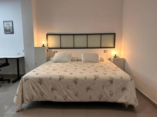 大加那利岛拉斯帕尔马斯HJS Guest House - The majestic Loft的卧室配有一张带白色棉被的床和一张书桌
