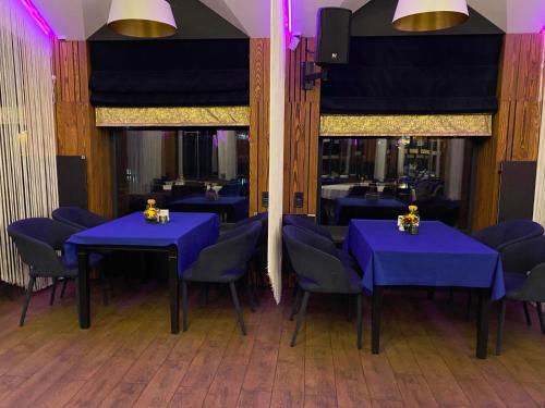 白采尔科维Rikabar Restaurant & nature的用餐室配有蓝色的桌子和蓝色的椅子