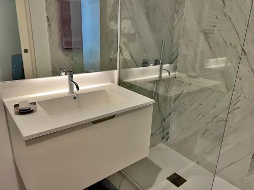 马托西纽什Alva Luxury Flat的白色的浴室设有水槽和淋浴。