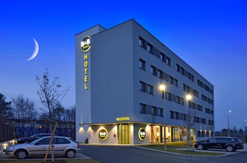 格拉茨B&B Hotel Graz City-Süd的门前有车辆停放的酒店