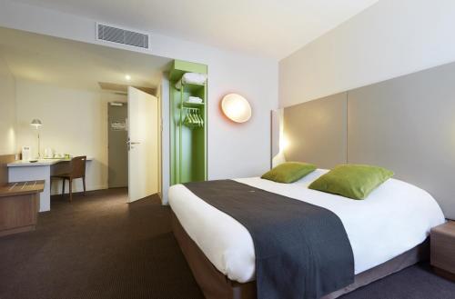 安纳马斯安纳马斯车站康铂酒店 - 日内瓦的酒店客房设有一张大床和一张书桌。