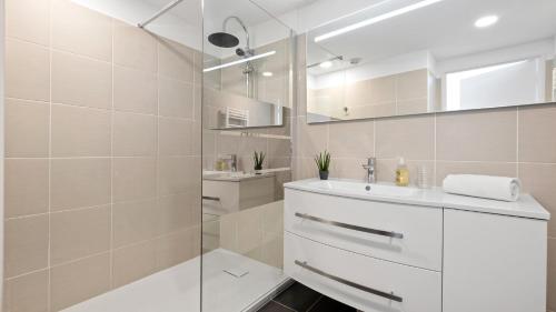 曼德琉-拉纳普勒Cannes Marina Appart Hotel Mandelieu的白色的浴室设有水槽和淋浴。