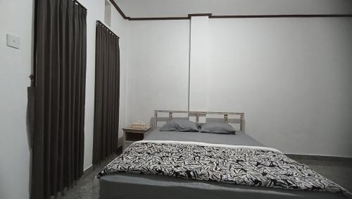乌布Gending Sari House的一间卧室配有一张带黑白色棉被的床