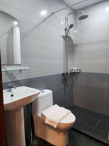 LocsinHOTEL HERENCIA 625 formerly Abaca Suites的浴室配有卫生间、盥洗盆和淋浴。