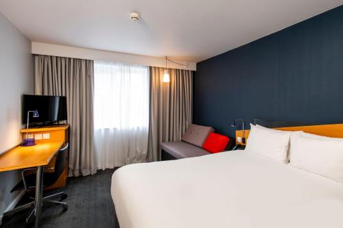 泰恩河畔纽卡斯尔Holiday Inn Express Newcastle Gateshead, an IHG Hotel的酒店客房设有一张大床和一张书桌。
