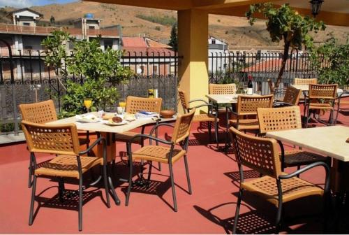 兰达佐Hotel Scrivano的庭院内的餐厅,配有桌椅