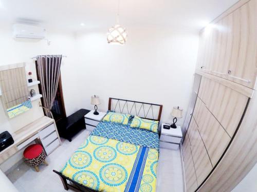 KalasanRumah Bungur, Purwomartani的一间卧室配有蓝色和黄色枕头的床