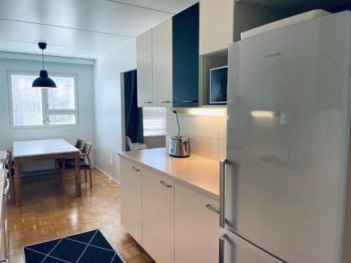 埃斯波Kalastajankuja Apartment的厨房配有不锈钢冰箱和桌子