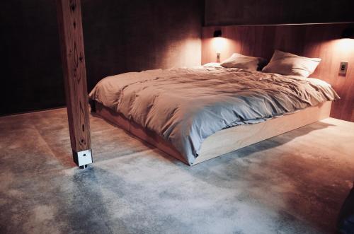 洲本市MAGATAMA.INN的一间卧室配有一张木架大床