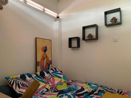莱特鲁瓦西莱Studioloc'Martinique的一间设有床铺的客房,墙上挂有图片