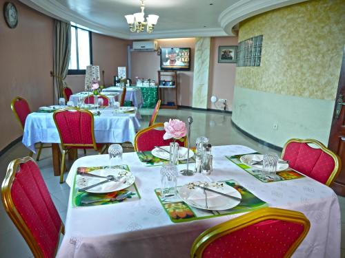 杜阿拉Residence Le Carat的用餐室配有桌椅和白色的桌布