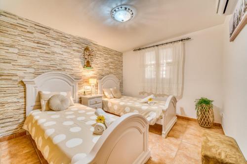 印加Ideal Property Mallorca - Can Caragol Inca的一间卧室设有两张床和砖墙