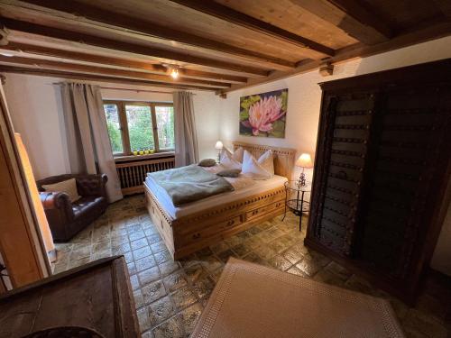 巴特维塞Alpen Suite Tegernsee - große Sonnenterasse und idyllischer Garten的卧室配有床、椅子和窗户。