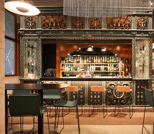 巴塞罗那兰布拉斯希尔肯酒店的一间酒吧,在房间内配有桌椅